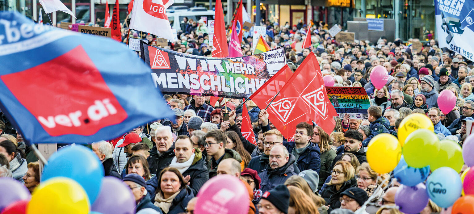 Menschenmenge mit Fahnen und Luftballons bei Demonstration