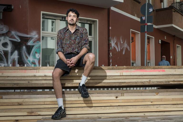 Portrait Anusch Cascorbi, sitzend vor Hauswand