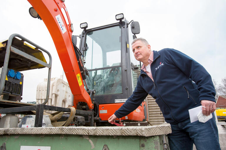 Der kleine Bagger muss für den Transport gesichert werden. Eschen kennt sich als Fachkraft für Arbeitsschutz damit aus.