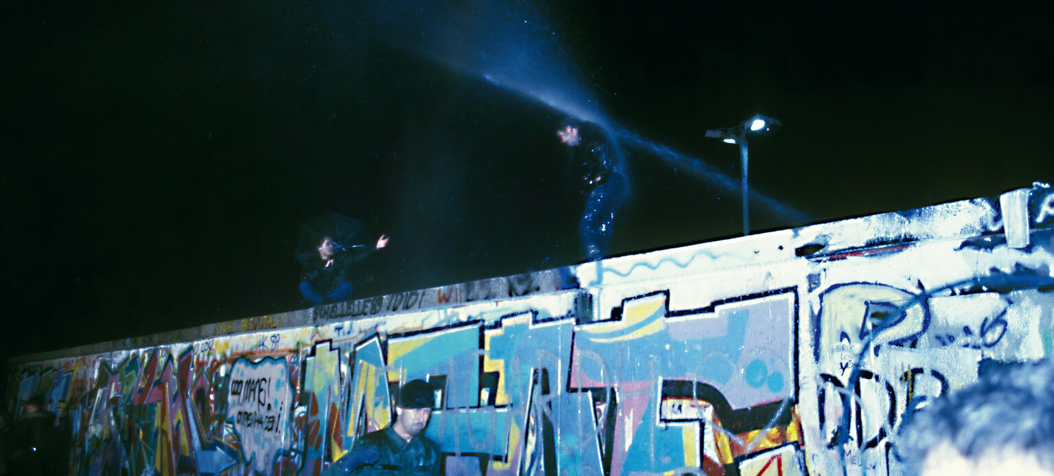 Am Abend des 9. November öffnet die DDR ihre Grenzen –es ist der Anfang vom Ende der deutschen Teilung. Das Besteigen derMauerkrone ist an diesem Abend noch eine gefährliche Angelegenheit.