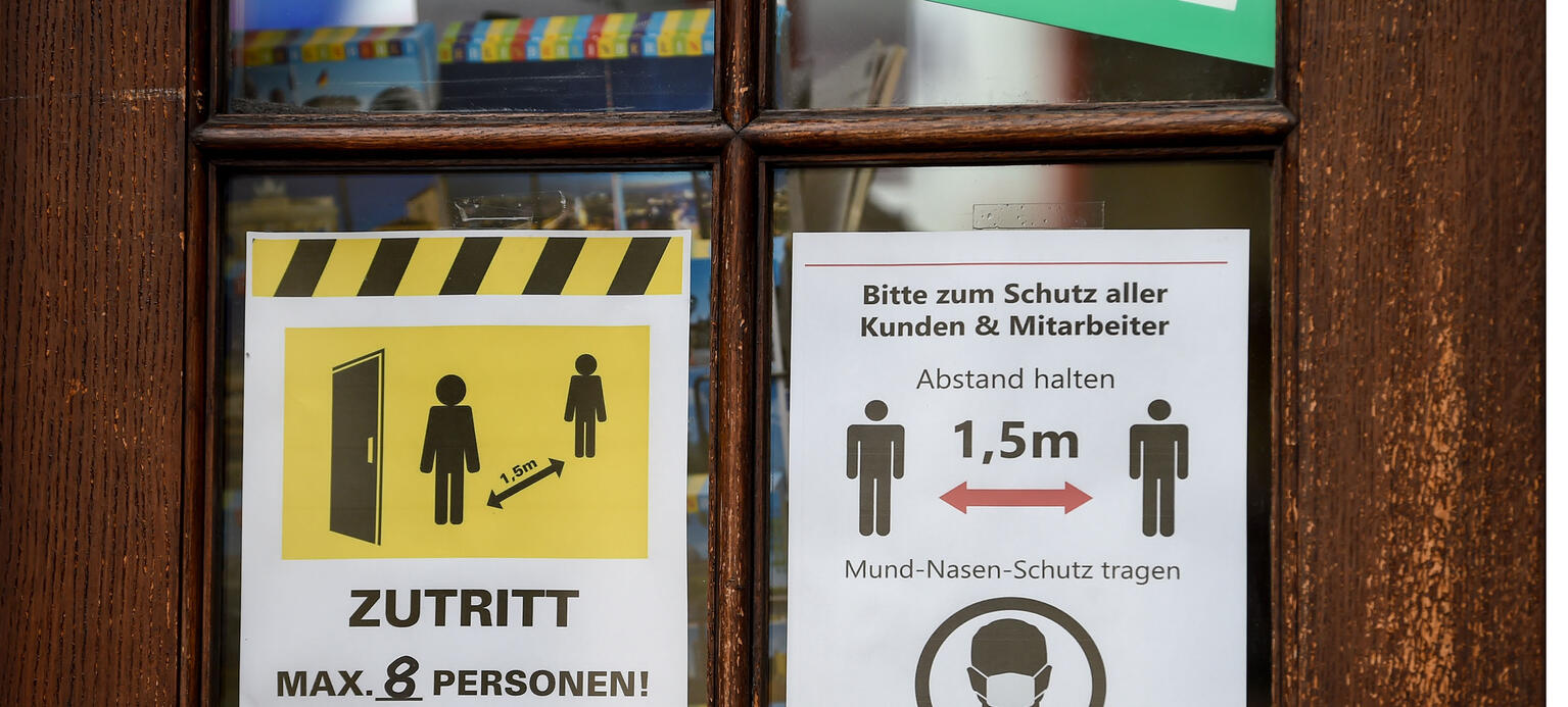 Coronasorgen - An der Tür eines Geschäfts hängen Schilder mit der Aufschrift „Zutritt max. 8 Personen! Vielen Dank!“ und „Bitte zum Schutz aller Kunden & Mitarbeiter Abstand halten - 1,5m - Mund-Nasen-Schutz tragen, vielen Dank!“ 