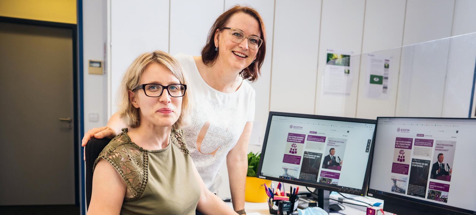 Die Schwerbehindertenvertreterin Tamara Eils (stehend) und Mitarbeiterin Miriam Stihulka in einem Büro mit einem Spezialstuhl bei Evonik in Hanau.