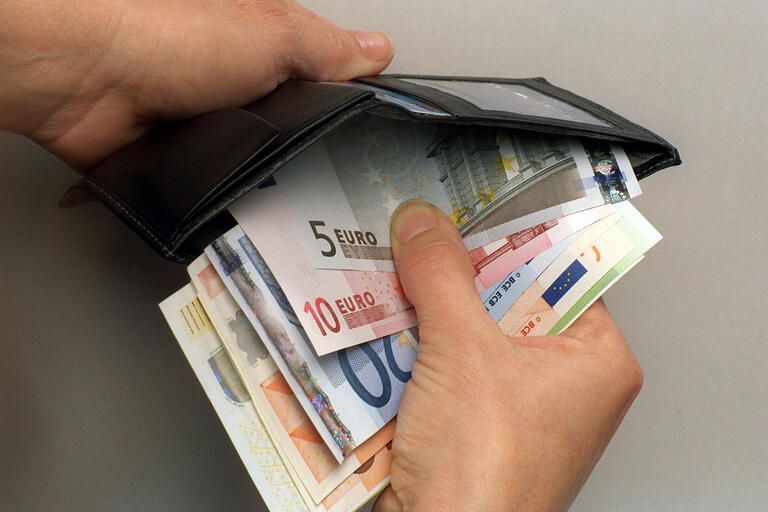 Eine schwarze Geldbörse mit Euro-Geldscheinen und -Münzen.