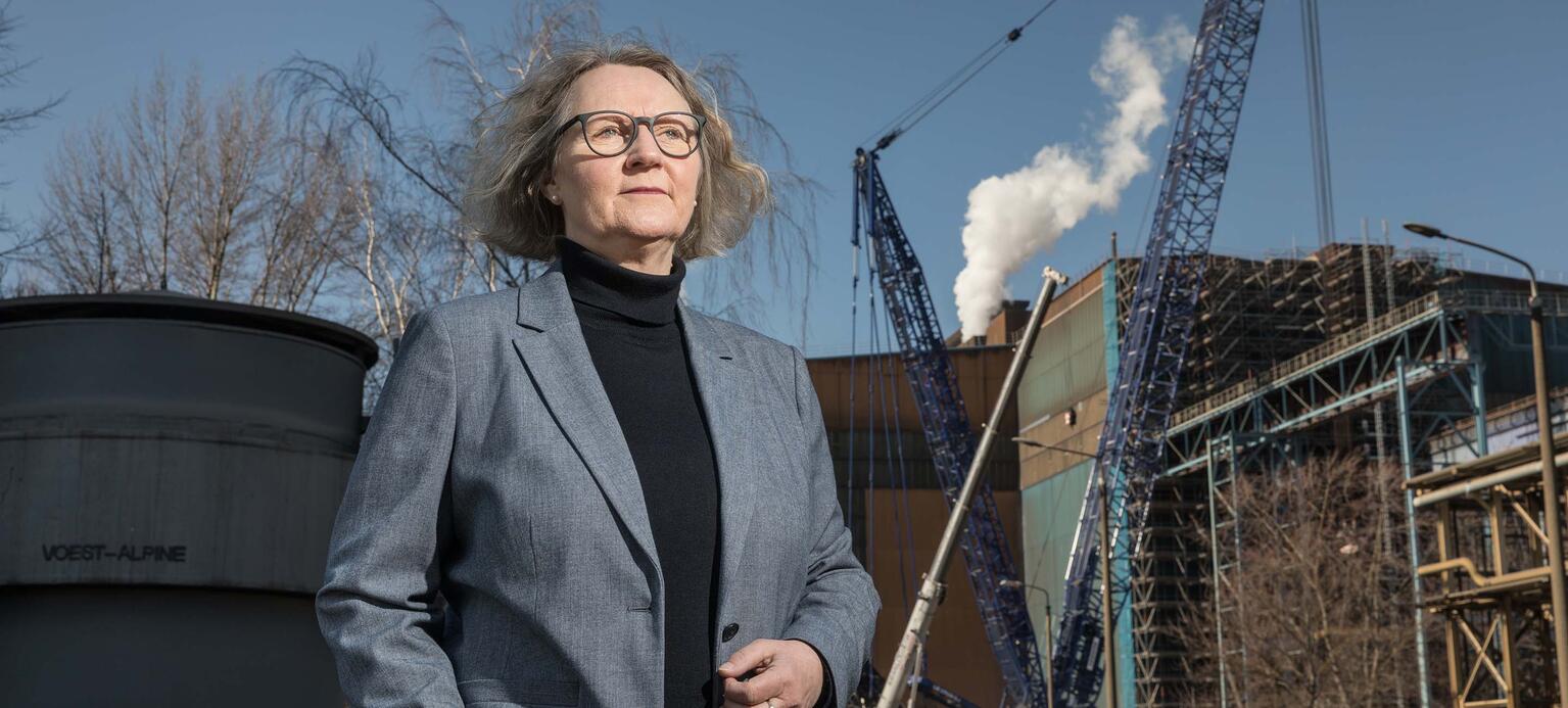 Anja Weusthoff, Aufsichtsrätin bei Arcelormittal Eisenhüttenstadt mit Kränen im Hintergrund