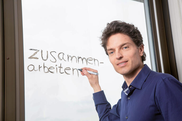 Porträt Enzo Weber, IAB Nürnberg mit Schriftzug 'Zusammenarbeit'