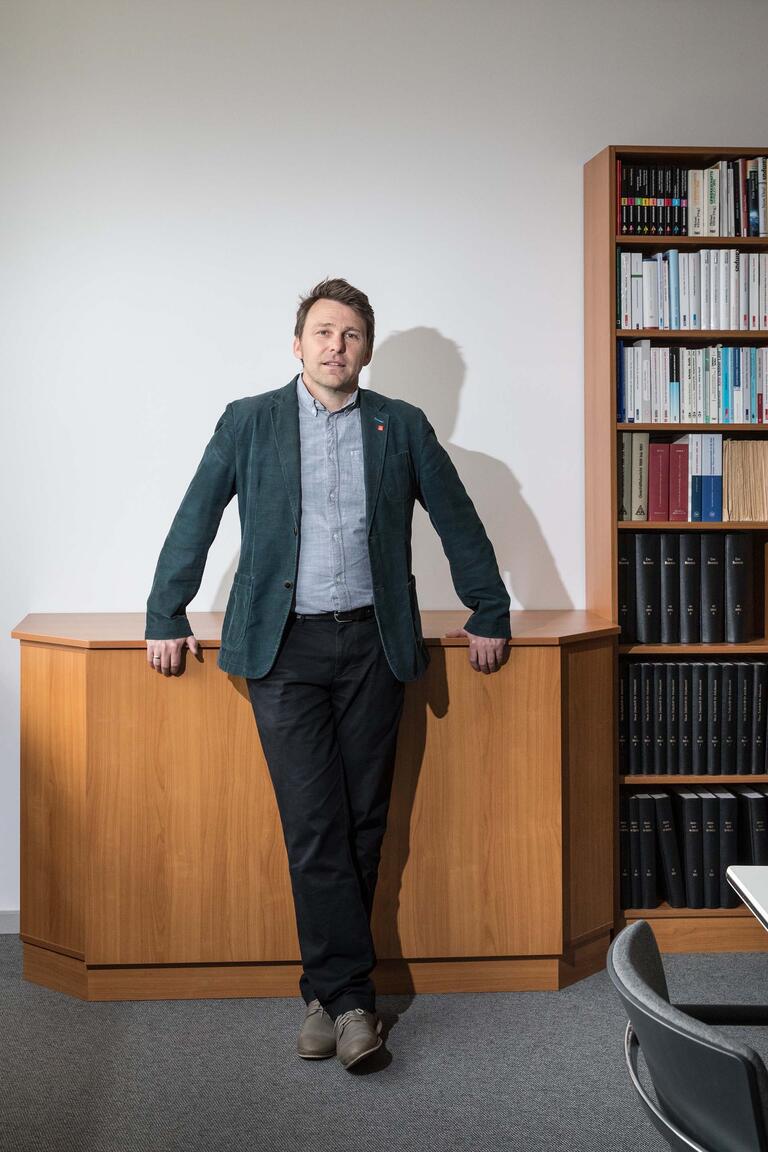 Porträt von Christoph Hahn vom IG Metall-Bezirk Berlin- Brandenburg-Sachsen in seinem Büro stehend