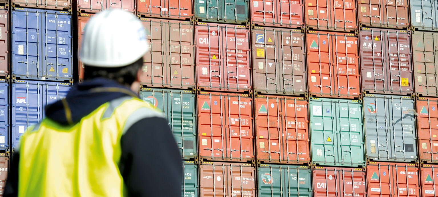 Hafenarbeiter in Hamburg vor einem Containerschiff
