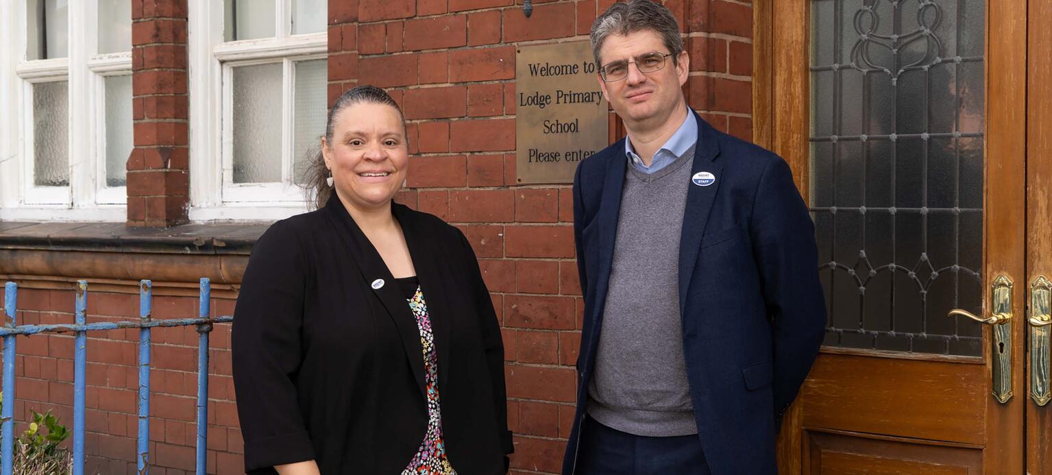 Grundschullehrerin Racquel Parchment (li.) und Fred Grindrod von der britischen Lehrergewerkschaft NASUWT vor einem Schulgebäude in England