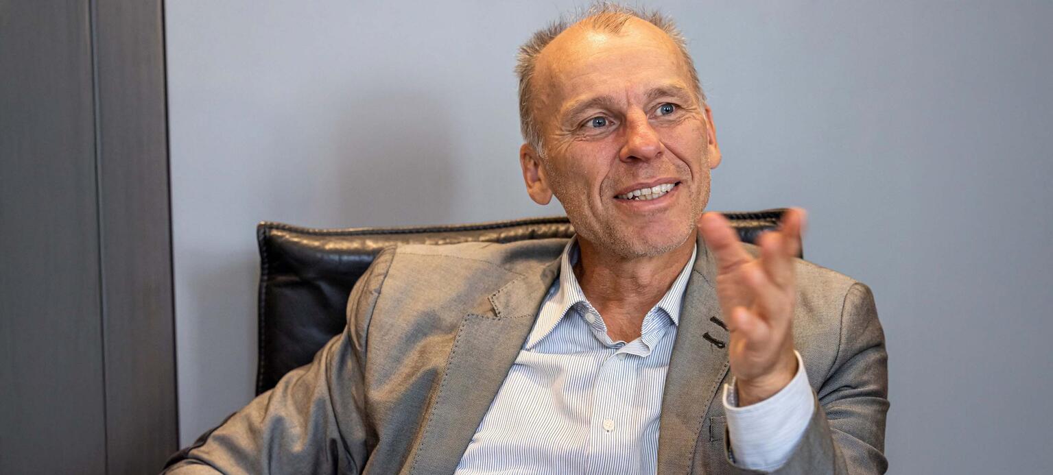 Porträt von Prof. Dr. Stefan Bratzel, Direktor des Center of Automotive, sitzend und redend