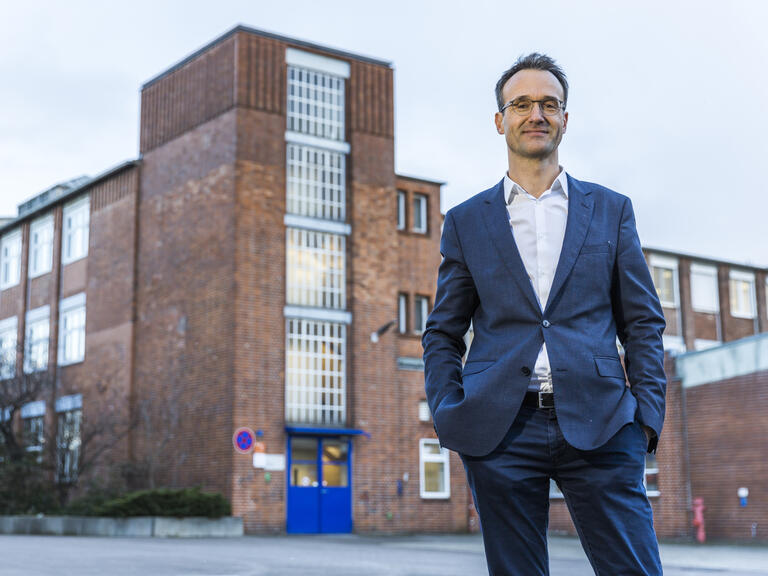 Stephan Kuserau, Stabsmitarbeiter für die Betriebsräte des Osram-Konzerns stehend vor Firmengebäude.fpläne und organisiert Klausursitzungen. Wenn die Kollegen ihre Arbeit gut tun können, ist Kuserau hochzufrieden.