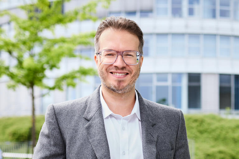 Das Foto zeigt Maximilian Waldmann, Preisträger 2025 vor einem Gebäude