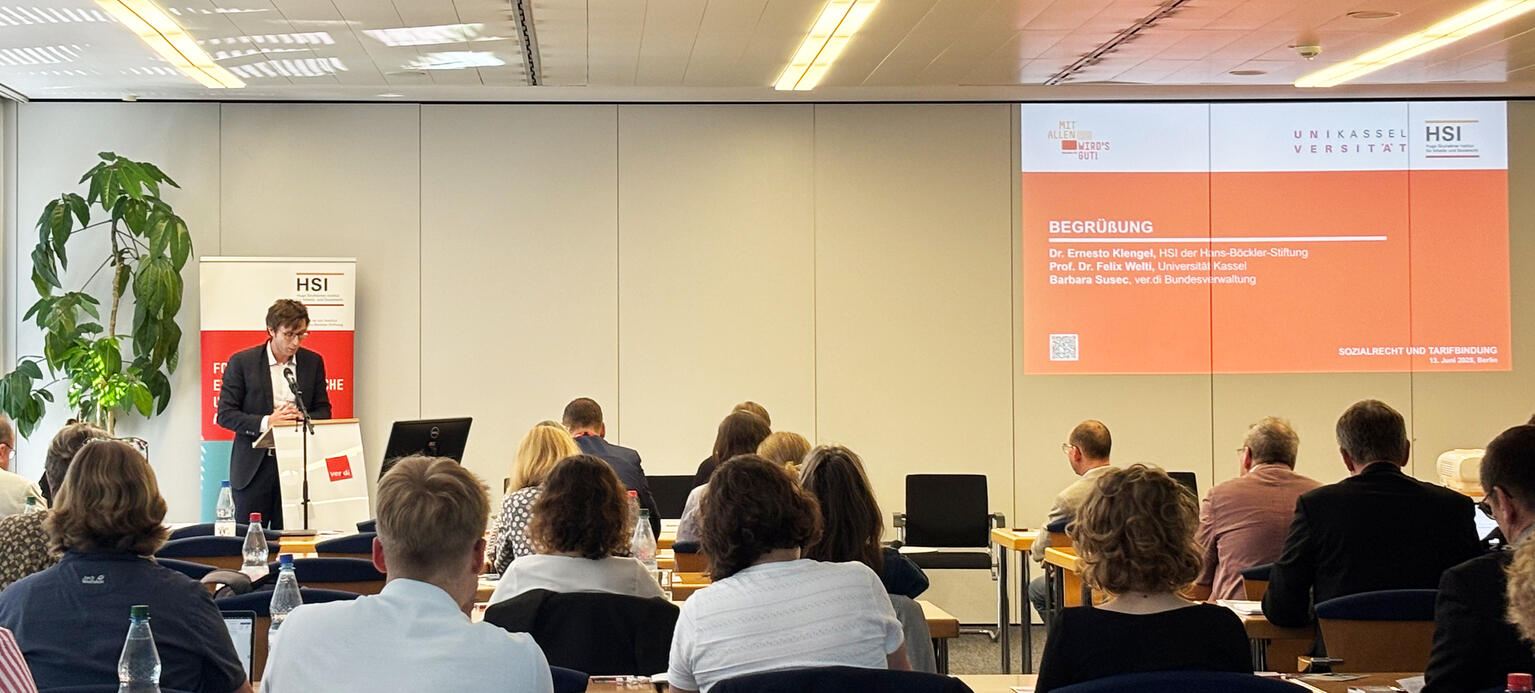 Zu sehen sind Bühne mit Vortragendem und Publikum bei der Pflegetagung des HSI 2025