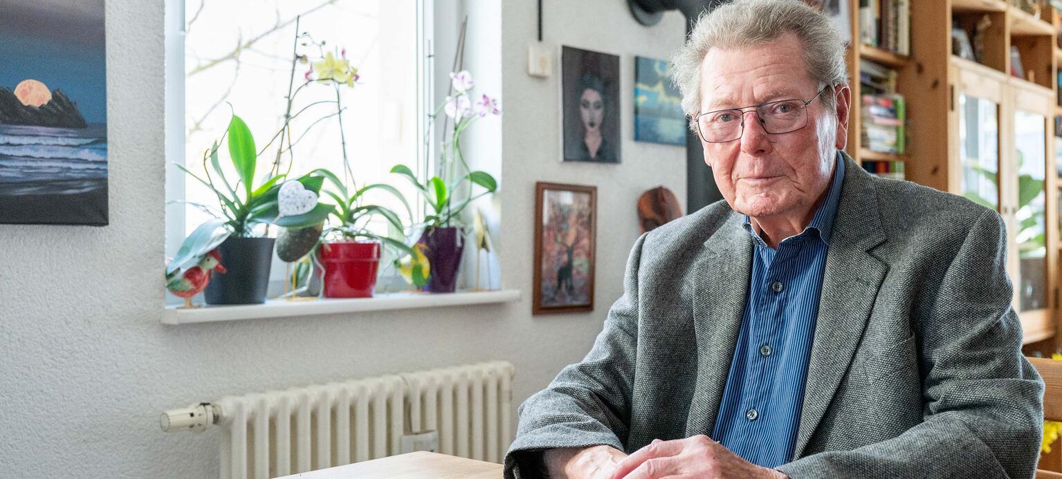 Porträt von Altstipendiat Kurt Roth zuhause am Tisch sitzend