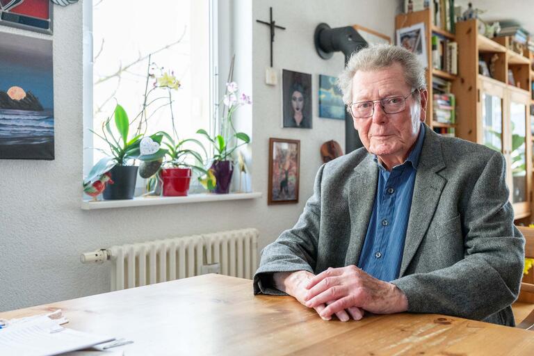 Porträt von Altstipendiat Kurt Roth zuhause am Tisch sitzend